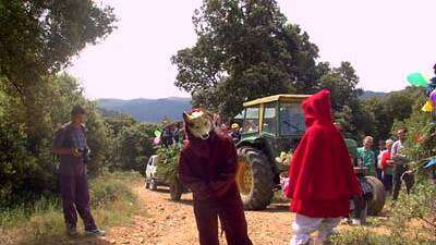 Caperucita sigue hablando con el Lobo, ante la atenta mirada de los ocupantes del segundo de los autobuses de montaña