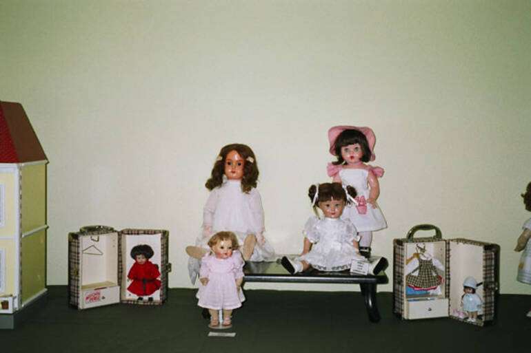 A la derecha, de rosa, Mariquita moderna. A su lado tres muñecas alemanas de principios del siglo XX. Flanquean la composición dos Mini-Mariquitas en sus cajas.